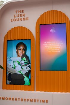 a woman holding a bouquet in front of a sign with the words the lush lounge on it