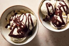 two bowls filled with ice cream and chocolate sauce