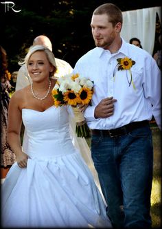 a bride and groom walking down the aisle at their outdoor wedding ceremony with sunflowers