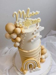 a three tiered cake with white frosting and gold decorations