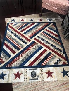 an american flag quilt is on the floor next to a red white and blue chair