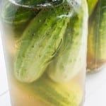 pickles are in a jar with water on the table