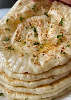 a stack of pita bread sitting on top of a white plate