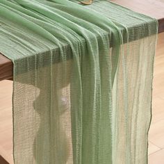 a green table runner on top of a wooden table