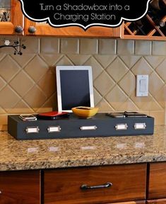 a kitchen counter with an electronic device and wine bottle on it that says turn a shadowbox into a charging station