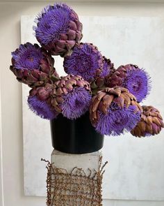 purple flowers in a black and white vase