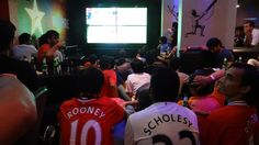 a group of people sitting in front of a flat screen tv on top of a wall