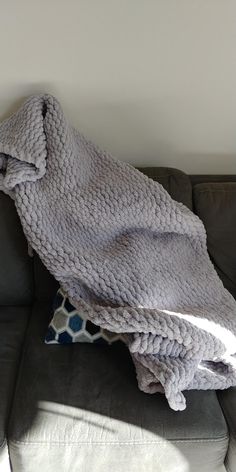 a gray blanket sitting on top of a couch