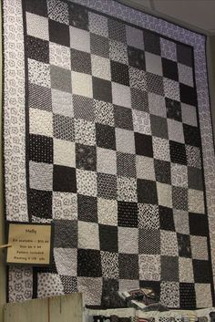 a black and white checkered quilt hanging on the side of a wall in a room