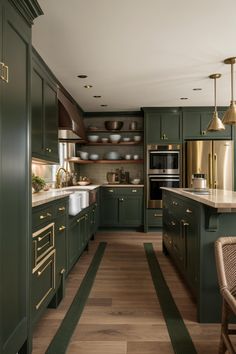 a kitchen with green cabinets and gold accents on the counter tops, along with a wooden floor