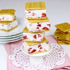 a stack of strawberry shortbreads sitting on top of a white plate next to crackers