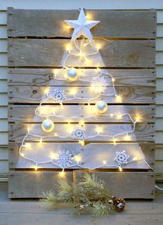 a christmas tree made out of pallet wood with lights on the top and around it