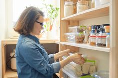 a woman is looking for food in the refrigerator