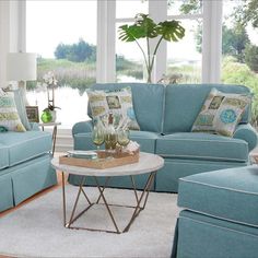 a living room filled with blue couches and pillows