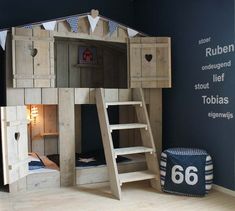 a child's bedroom with bunk beds and ladders on the floor, next to a blue wall