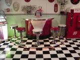 an old fashioned kitchen with checkered flooring and red appliances on the counter top