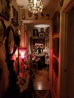 the hallway is lit up with red lights and pictures on the wall above it, along with other decor