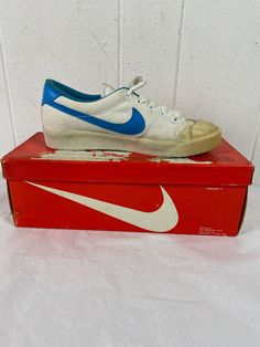 "Women's vintage 1980s white canvas with blue swoosh tennis shoes. Called Lady all court. Size 5 1/2 Actual measurements are: 9 5/8\" toe to heel across the soles 3 1/4\" across the soles widest point (ball of the foot) In excellent unused condition. New in original box. New old stock. The in soles and arch supports are all in good condition. There is some yellowing to the rubber from age, and some yellowing spots on canvas." Vintage White Skate Shoes With Rubber Waffle Outsoles, Vintage Sports Sneakers With Gum Sole, Vintage Skate Shoes With Rubber Sole For Sports, Vintage Sneakers With Perforated Toe Box, Vintage White Sneakers With Gum Sole, Vintage Low-top Skateboarding Sneakers, Vintage High-top Skate Shoes For Sports, Vintage Low-top Skate Shoes With Vulcanized Sole, Vintage Skate Shoes With Vulcanized Sole For Sports