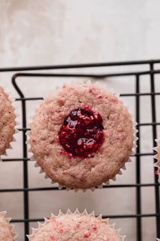 several cupcakes with cranberry filling on a wire rack next to each other