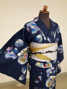 This cotton kimono aka Yukata has a charm of multiple colour flowers like aquarel paintings on blue background.  I was willing to set up this combo featuring on to gray and   camel brown which are most modest ones among the colours. You can see it on the obijime string with silver threads and the obi belt which is reversible of gray and milk tea brown. As a result, an atmosphere as following is shown;  a flower garden shining under the beams of the new Moon. This combo is for whom has a down-to- Blue Kimono For Spring Tea Ceremony, Traditional Blue Floral Kimono, Traditional Blue Floral Print Kimono, Blue Kimono With Kimono Sleeves For Tea Ceremony, Traditional Blue Kimono For Tea Ceremony, Obi Belts, Colour Flowers, Yukata Kimono, Obi Belt