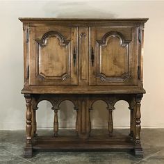 an old wooden cabinet sitting on top of a tile floor