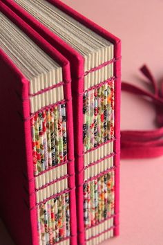 two books are sitting on a pink surface