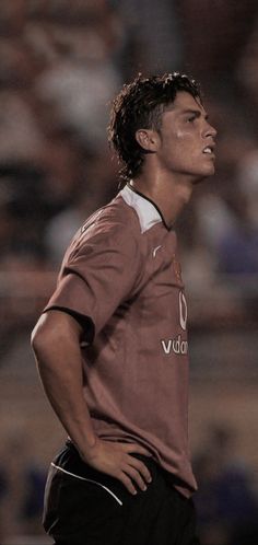 a man standing on top of a soccer field with his head turned to the side