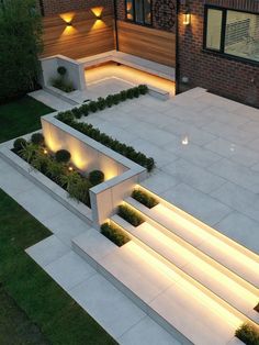 an aerial view of a modern house with steps lit up and landscaping in the foreground