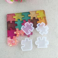 four pieces of puzzle sitting next to each other on a table with flowers in the background