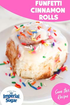 a white plate topped with a piece of cake covered in frosting and sprinkles