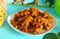 a plate full of fried chicken nuggies next to a bowl of cheetos