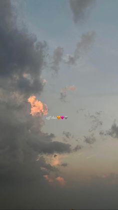 two kites flying in the sky on a cloudy day with pink and blue clouds