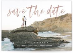 the save the date card is shown on top of rocks near the ocean and mountains