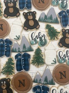 decorated cookies are arranged in the shape of teddy bears and sweaters with trees on them