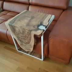 a wooden table sitting on top of a brown couch