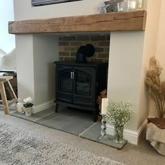 a living room with a wood burning stove in the corner and rug on the floor