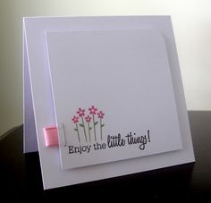 a white card with pink flowers and the words enjoy the little things written on it