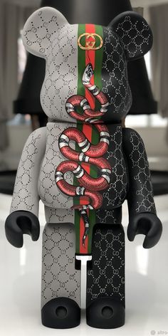 a black and white bear with a red snake on it's chest, sitting on a table