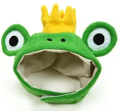 a green frog with a crown on its head and big eyes is shown in front of a white background