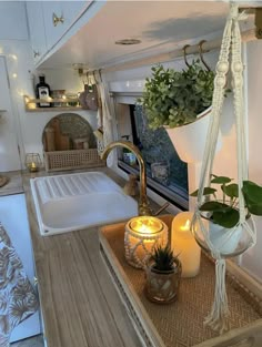 the interior of a camper with plants and candles on it's countertop