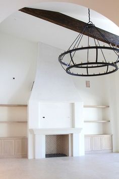 an empty living room with a fireplace and ceiling fan