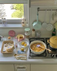 the kitchen counter is cluttered with dishes and cooking utensils, including an oven