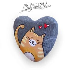 a heart shaped rock with a cat sleeping on it's back and hearts in the air