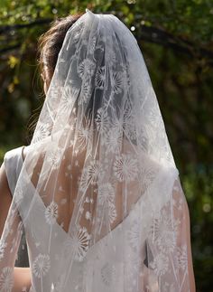 the back of a bride's veil with dandelions on it