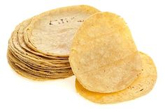 a stack of tortilla chips sitting next to each other on a white surface