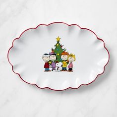 a white plate with a christmas tree on the front and three cartoon characters on it