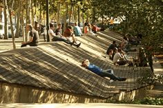 many people are sitting on the roof of some buildings and one person is laying down