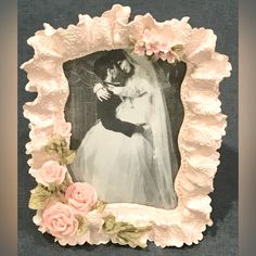 a wedding photo frame with pink roses on the bottom and an image of a bride and groom