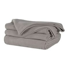 the grey blanket is folded up on top of each other, and it's ready to be used as a bed