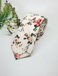 "Our Rosy floral tie is a skinny tie which features a mixture of gorgeous roses in colours of pink, peach, maroon  and green. It is the perfect tie for weddings, formal occasions, proms, graduations or simply for work.  Made  from 100% Cotton Tie Measurements Width - 6 cm or 2.36\" Length - 145cm or 57\" The Rosy floral tie matches with the Dusty Rose Ties & Bow Ties available here -  https://www.etsy.com/listing/1510525111/dusty-rose-tie-groomsmen-tie-pink-tie CARE INSTRUCTIONS Dry Clean only Spot Clean Warm Iron Please note if you require more than the displayed amount in stock please message me with the date you require the items as I may have more available for purchase. Great gift for your husband to be, father, groomsmen, Son, boyfriend or uncle! SHIPPING & PROCESSING TIME Processing Classic Floral Print Wedding Tie, Elegant Floral Print Suit And Tie Accessories For Groom, Classic Floral Print Tie For Gift, Classic Floral Print Tie As A Gift, Classic Floral Print Ties As Gifts, Floral Print Standard Tie For Wedding, Wedding Suit Accessories With Floral Print Standard Tie, Floral Print Tie For Groom, Floral Print Ties For Groom